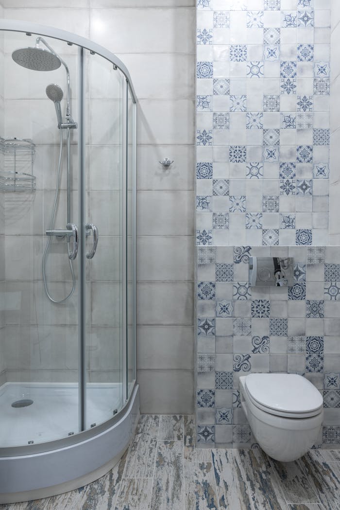 creative-03 Contemporary bathroom featuring a glass shower and patterned tile wall for a stylish look.